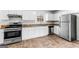 Well-lit kitchen features white cabinetry, stainless steel appliances and granite countertops at 2916 Ward Lake Way, Ellenwood, GA 30294