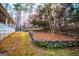 Landscaped backyard featuring mature trees and stone retaining wall at 7364 N Mitchell Ct, Villa Rica, GA 30180