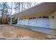 Attached yellow garage featuring three white carriage doors and extra covered parking at 7364 N Mitchell Ct, Villa Rica, GA 30180