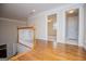 Upstairs hallway featuring hardwood floors, white railing and views into bedroom and hall closet at 7364 N Mitchell Ct, Villa Rica, GA 30180