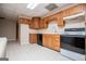 Kitchen featuring wooden cabinets, black appliances and light tile flooring at 7364 N Mitchell Ct, Villa Rica, GA 30180