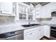 Corner view of kitchen featuring gray countertops, stainless steel appliances, and white cabinets at 7364 N Mitchell Ct, Villa Rica, GA 30180