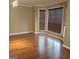 Bright living room featuring gleaming hardwood floors, large windows with blinds, and neutral paint at 10020 Crystal Ter, Jonesboro, GA 30238