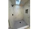 Modern shower featuring marble-like tile, a skylight, and a niche for toiletries at 115 Paces Way, Fayetteville, GA 30215