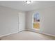 Cozy bedroom with plush carpeting, a large, arched window and closet at 6973 Stephens Dr, Rex, GA 30273