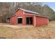 Large red workshop featuring two garage doors, suitable for various projects and storage at 62 Honey Ln, Mcdonough, GA 30252