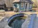 Outdoor pool with a blue tiled jacuzzi, next to a fireplace and outdoor grill at 1187 Attaway Road, Roopville, GA 30170