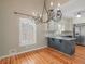 Eat-in kitchen area featuring a chandelier, island, and a window with shutter blinds at 135 Oakpark Ter, Mcdonough, GA 30253