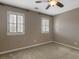Carpeted bedroom featuring two windows with plantation shutters at 135 Oakpark Ter, Mcdonough, GA 30253