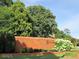 Community entrance with brick wall, Oak Park signage, landscaping, and mature trees at 135 Oakpark Ter, Mcdonough, GA 30253