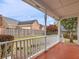 Inviting covered porch with white railing overlooks the landscaped backyard and wooden fence at 135 Oakpark Ter, Mcdonough, GA 30253