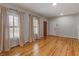 Spacious living room with hardwood floors, two windows and neutral paint at 135 Oakpark Ter, Mcdonough, GA 30253