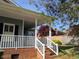 Charming front porch with brick base and white railings leads to the entrance of the home at 135 Oakpark Ter, Mcdonough, GA 30253