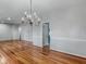 Dining room with chandelier, hardwood floors, and view into the entry and another room at 135 Oakpark Ter, Mcdonough, GA 30253