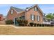 Side view of a brick home featuring a two-car garage and green accents at 135 Oakpark Ter, Mcdonough, GA 30253