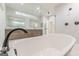 Modern bathroom featuring a soaking tub, double vanities, and a glass-enclosed shower at 2015 Fontainbleau Dr, Conyers, GA 30094