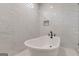 Bright bathroom features a soaking tub with black fixtures and stylish marble tiled wall at 2015 Fontainbleau Dr, Conyers, GA 30094