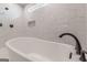 Close-up of a stylish soaking tub with black matte fixtures and elegant marble wall tiles at 2015 Fontainbleau Dr, Conyers, GA 30094