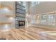 Living room showcasing modern fireplace and large windows providing an abundance of natural light and hardwood floors at 2015 Fontainbleau Dr, Conyers, GA 30094