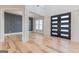 Open living room with hardwood floors, stylish accent wall, and an adjacent hallway at 2015 Fontainbleau Dr, Conyers, GA 30094