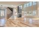 Open-concept living room with modern fireplace, staircase, large windows, and natural hardwood floors at 2015 Fontainbleau Dr, Conyers, GA 30094