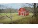 Charming red barn with white trim, adding a touch of rustic charm to the property at 757 Fischer Rd, Sharpsburg, GA 30277