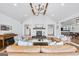 Open-concept living room with a stone fireplace, hardwood floors, and views to the kitchen at 757 Fischer Rd, Sharpsburg, GA 30277