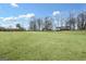 Expansive green field featuring the home in the distance, offering ample space and scenic views at 757 Fischer Rd, Sharpsburg, GA 30277