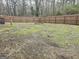 Large backyard with a wooden privacy fence and scattered green moss at 3930 W Side Pl, Ellenwood, GA 30294