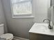 Bathroom featuring a white basin sink, toilet, and a window at 3930 W Side Pl, Ellenwood, GA 30294
