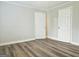 Neutral bedroom featuring hardwood floors and two white doors, offering a blank slate at 3930 W Side Pl, Ellenwood, GA 30294