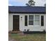 Close up of front door and window with black shutters and well-maintained landscaping at 3930 W Side Pl, Ellenwood, GA 30294