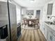 Eat-in kitchen with white cabinets, stainless steel appliances and a round dining table at 3930 W Side Pl, Ellenwood, GA 30294