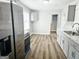 Galley kitchen with stainless steel appliances, white cabinets, and durable floors at 3930 W Side Pl, Ellenwood, GA 30294