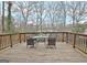 An outdoor patio deck with a table and chairs overlooking a peaceful wooded area at 101 Nightwind Ct, Peachtree City, GA 30269