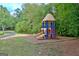 Community playground with slides and climbing structure surrounded by mature trees at 101 Nightwind Ct, Peachtree City, GA 30269