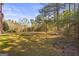 Expansive grassy backyard with mature trees provides a private and serene outdoor space at 100 Windmeadow Way, Fayetteville, GA 30214