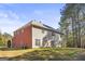 Large backyard featuring lush lawn and mature trees surrounding a two-story house at 100 Windmeadow Way, Fayetteville, GA 30214