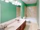 Well-lit bathroom featuring double sink vanity, tiled shower and bathtub combination with neutral tile at 100 Windmeadow Way, Fayetteville, GA 30214