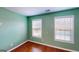 Comfortable bedroom featuring two windows with natural light, hardwood floors and neutral paint at 100 Windmeadow Way, Fayetteville, GA 30214