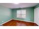 Bright bedroom with green walls and hardwood floors, bathed in natural light from a large window at 100 Windmeadow Way, Fayetteville, GA 30214