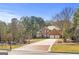 Red brick home with a three-car garage, lush landscaping, and brick driveway at 100 Windmeadow Way, Fayetteville, GA 30214