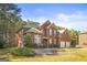 Beautiful two-story red brick home with an attached three-car garage and manicured landscaping at 100 Windmeadow Way, Fayetteville, GA 30214