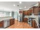 An open kitchen features wood floors, stainless steel appliances and granite countertops at 100 Windmeadow Way, Fayetteville, GA 30214