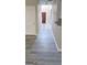 Hallway featuring gray wood-look flooring, white trim, and view of a red front door at 801 Winbrook Dr, Mcdonough, GA 30253