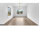 Well-lit dining room featuring hardwood floors, large windows, and a modern chandelier at 130 Windchime Way # 9, Tyrone, GA 30290