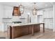 Close up of a modern kitchen with a large island, designer lighting, and stainless steel appliances at 130 Windchime Way # 9, Tyrone, GA 30290