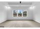 Bright main bedroom with plush carpet, recessed lighting, and a scenic view of the lake through large windows at 130 Windchime Way # 9, Tyrone, GA 30290