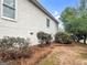 Side view of home's back exterior, with light siding, and manicured landscaping at 9135 Woodhaven Way, Mcdonough, GA 30253