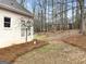 Backyard featuring a lawn with pine straw mulch, with an adjacent home in background and blue sky at 9135 Woodhaven Way, Mcdonough, GA 30253